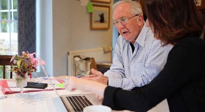 A man and a woman looking at a laptop computer.