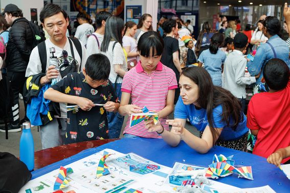 UK DRI researcher helps young family with origami activity at Great Exhibition Road Festival stall