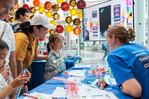 UK DRI researcher speaks with young girl at Great Exhibition Road Festival stall