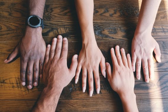 Hands of various skin colours placed side by side