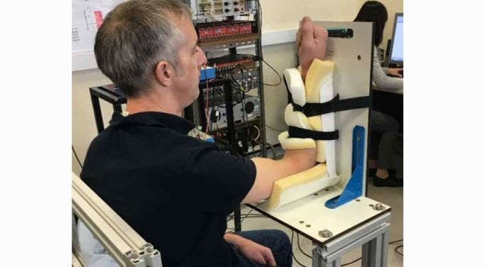 Participant undertaking upper limb contractions during the experiment. 