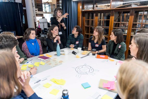 A group of people sit around a table working on a hackathon