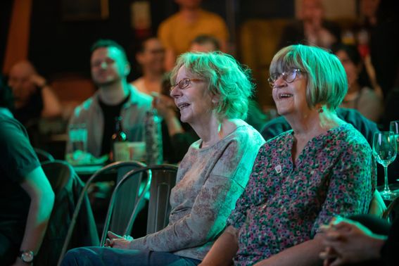 Two women smiling in a crowded audience