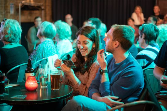 Man and woman smile in the audience at the annual festival