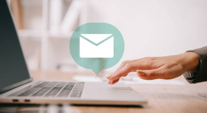 Photo of lady's hand hovering over laptop composing an email