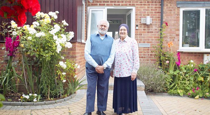 Couple standing outside their house