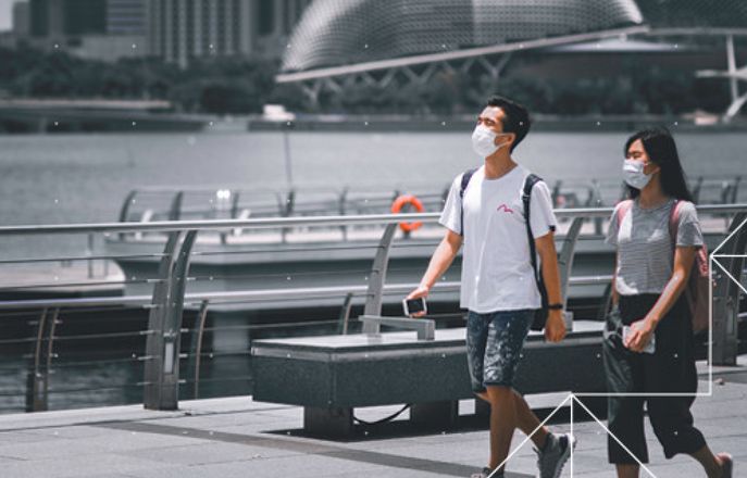 Two people walking wearing face masks