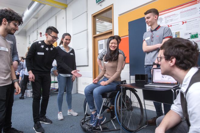 A student is sat in a wheelchair, surrounded by other students