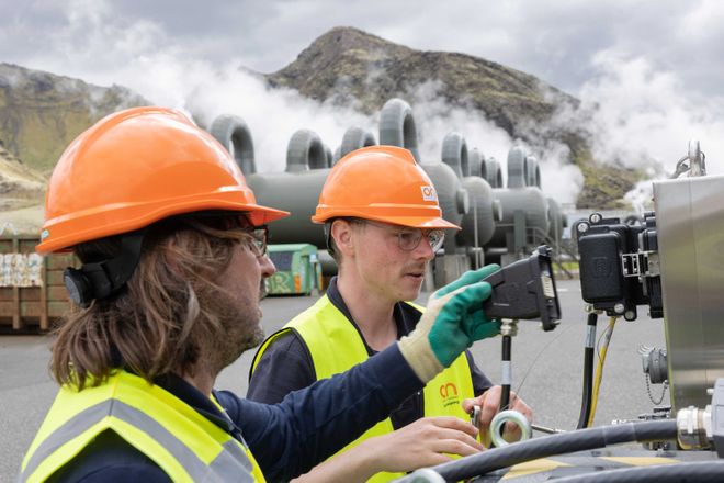 Two people working at a geothermal energy plant in Iceland