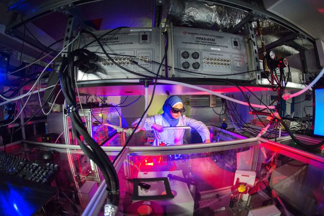 A researcher wearing protective glasses adjusts a device used for ultrafast molecular imaging