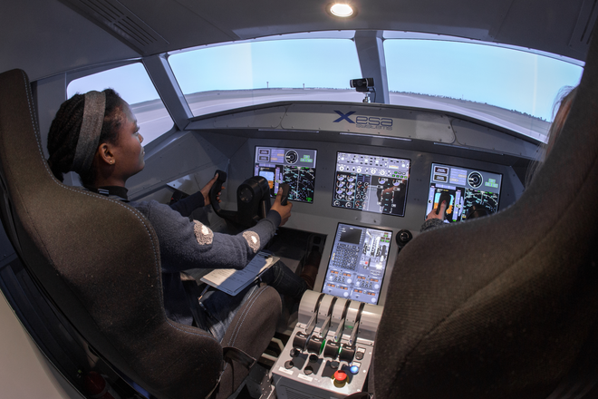 Student operates flight simulator in the Department of Aeronautics