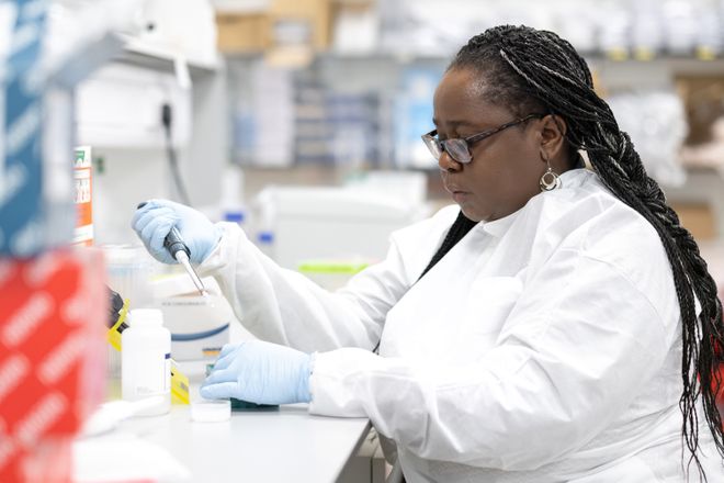 A picture of Catherine Kibirige Research Associate in a laboratory