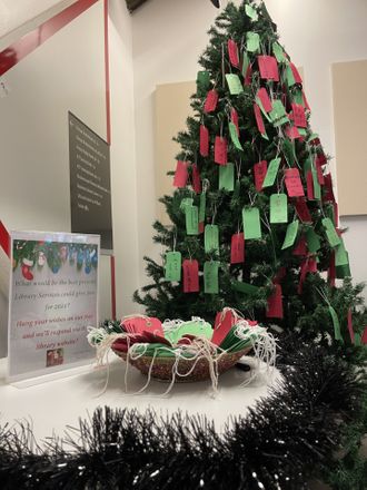 A Christmas tree decorated with feedback tags in festive colours