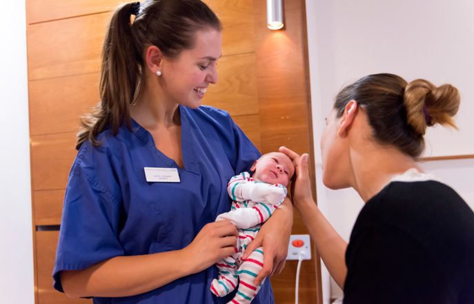 Nurse holding new born baby