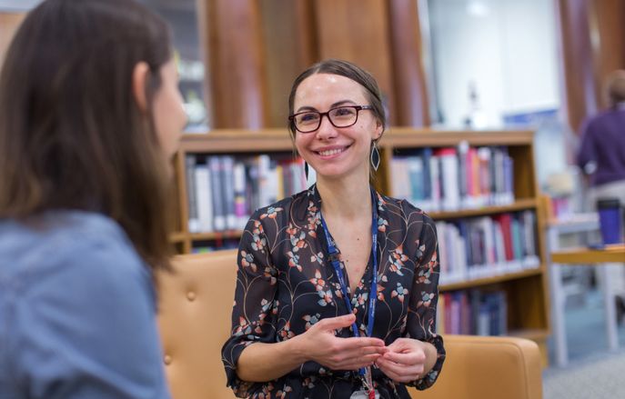A Master's student smiling in the Fleming Library at Imperial's St Mary's Campus