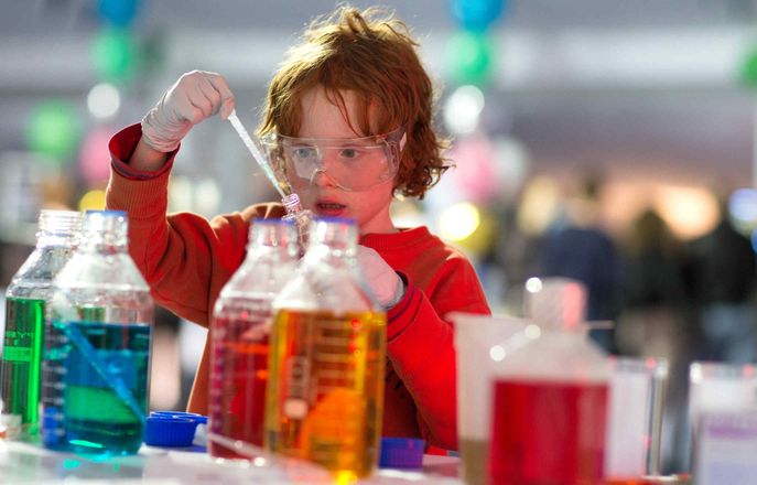 Kid in a lab doing an experiment
