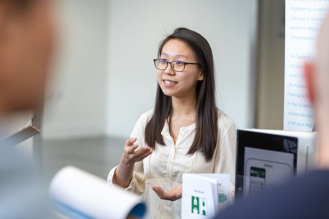 A lecturer talks to a group of students