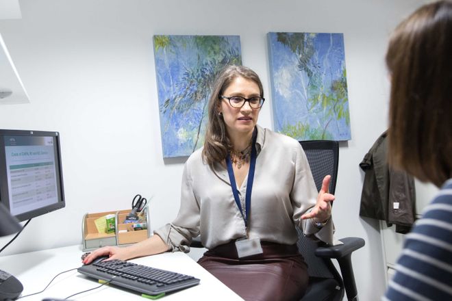 Katharina Hauck at a desk talking to someone