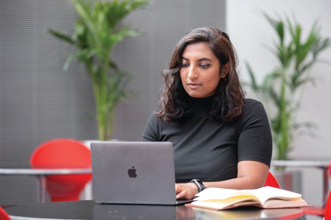 Postgraduate student sitting at desk with laptop