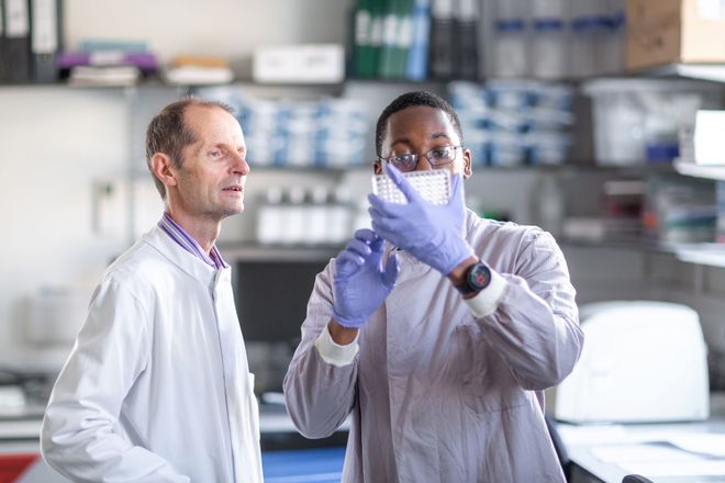 Professor Robin Shattock and a researcher look at samples in the lab