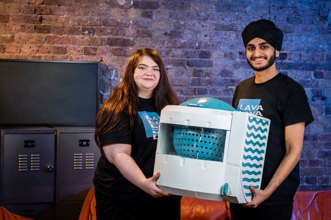 The two co-founders of Lylo stand holding their product, which recycles water