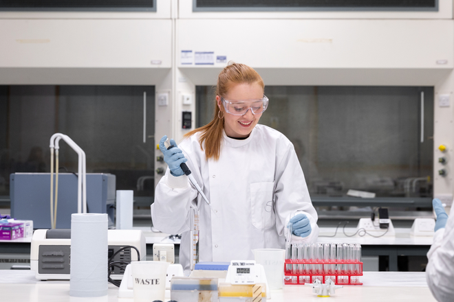 A student pipetting in the Barber Chemistry teaching laboratory.