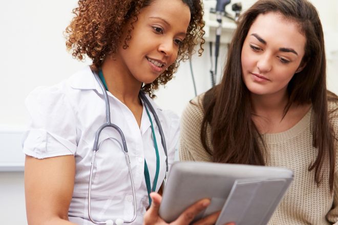 A picture of a doctor and a patient looking at an ipad