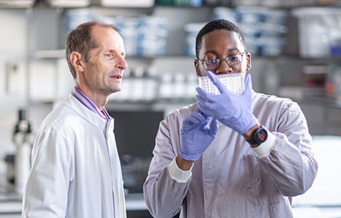 Professor Robin Shattock in a lab with a researcher