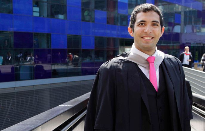 A student wearing robes on graduation day