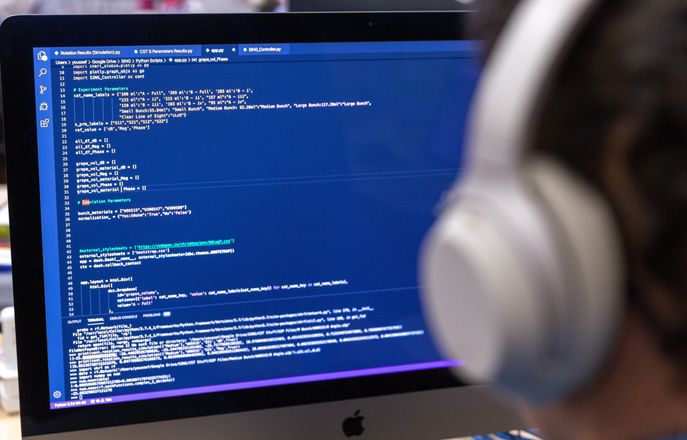 student looking at code on a monitor