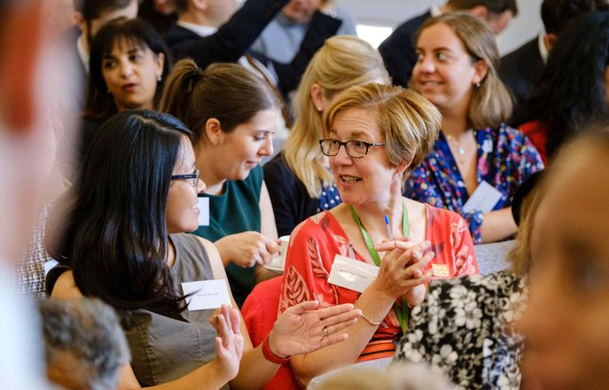 Two women talking in an audience at a patient safety event