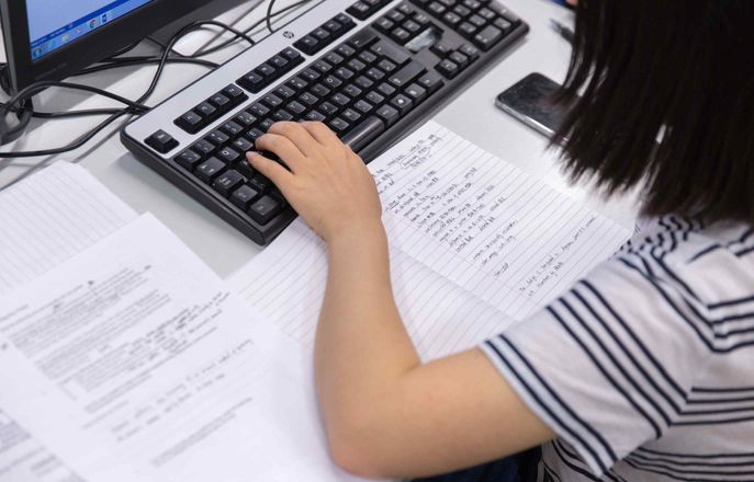 Student writing on a computer