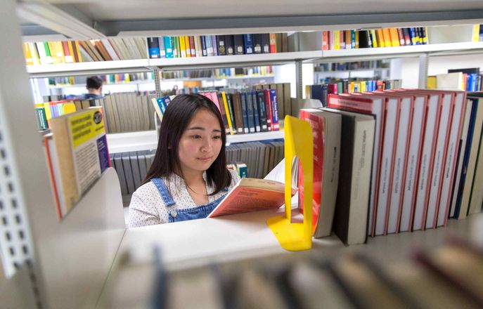 Student searching for books in the library