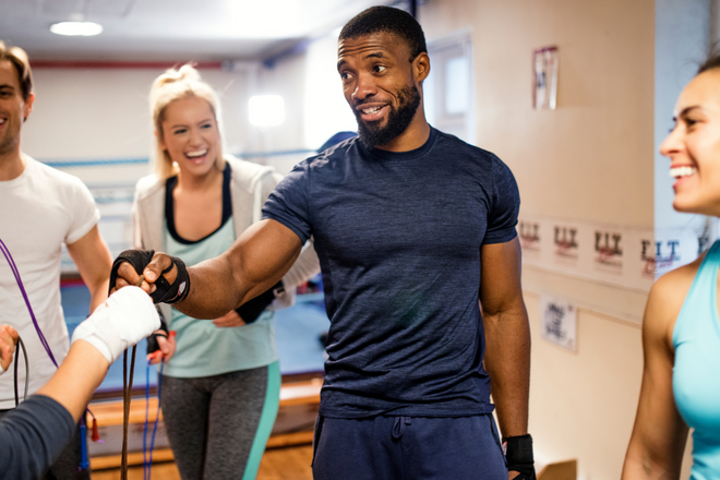 A man speaking with a group in an exercise class