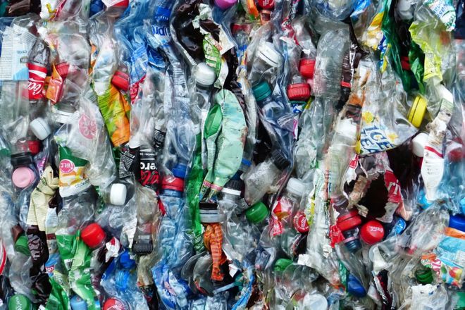 A bale of plastic bottles of all colours, flattened together and ready for recycling