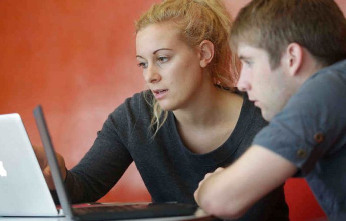 Students working together around a laptop