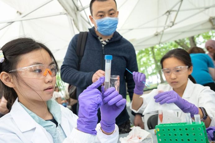 Children interacting with the extract DNA from a strawberry exhibit