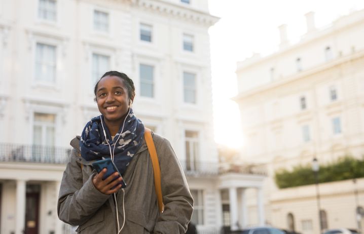 A student smiling as she walks on campus.