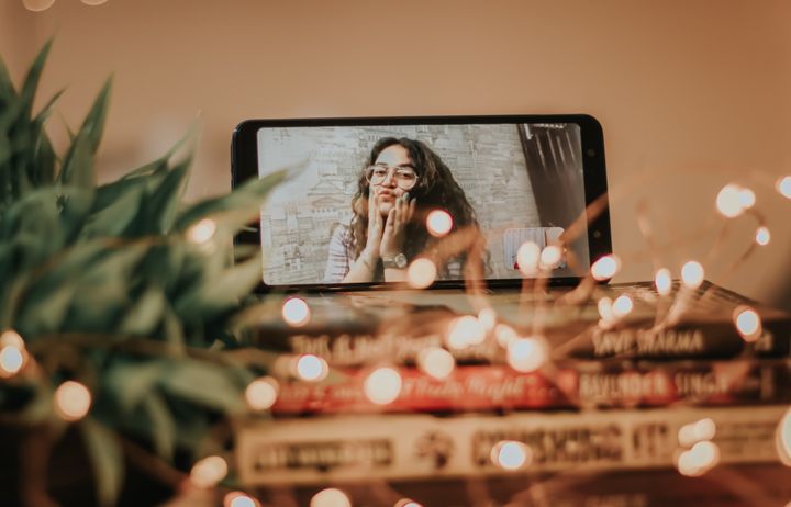 desk with a phone propped up doing a video call