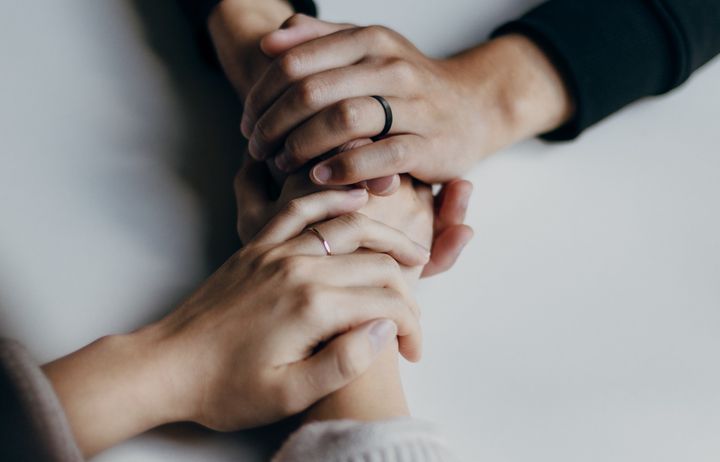 two people holding hands over table