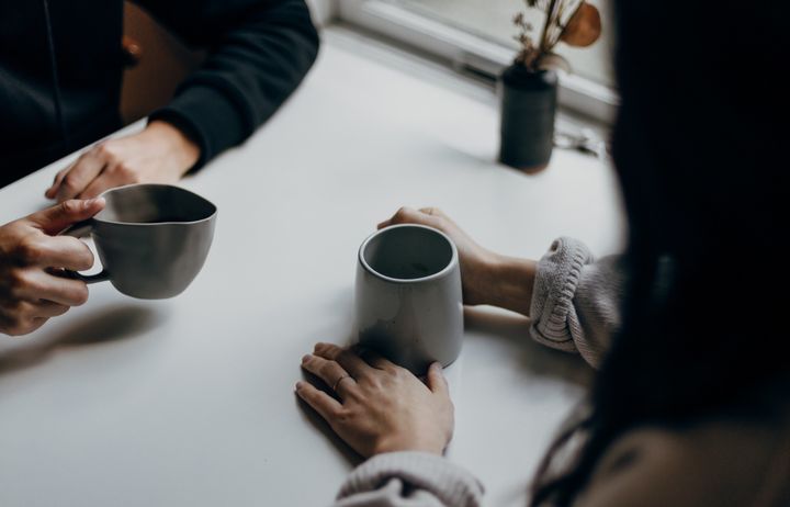 two people drinking coffee and talking