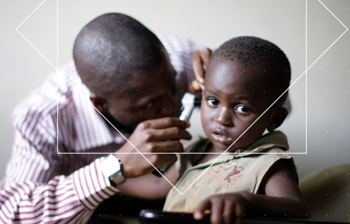 A doctor taking looking in a child's ear