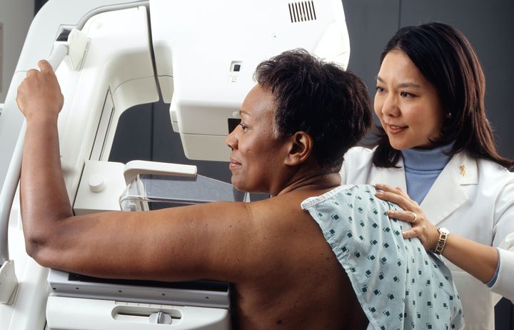 Woman have a mammogram being assisted by a female mammographer 