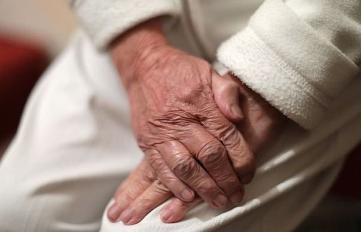 Persons hands folded on their lap