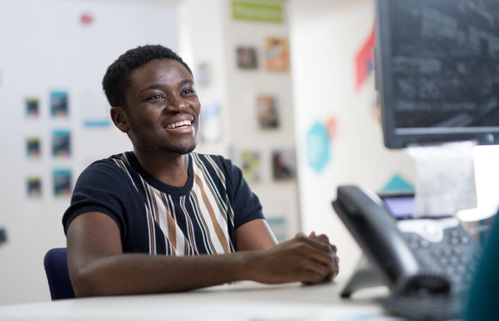 Student on campus smiling with support staff