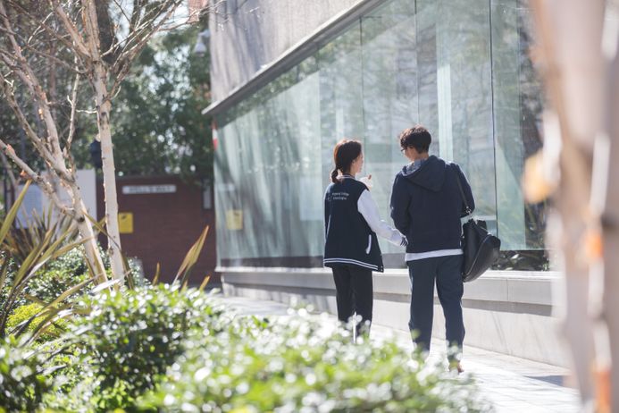 Two students walking on campus with an ice cream