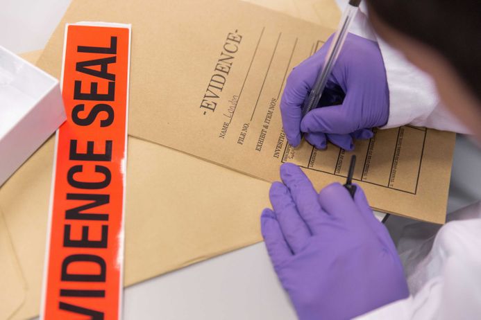 Gloved hands with evidence envelope