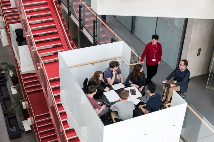 A research team meet in a break-out space in the atrium of Imperial Centre for Translational and Experimental Medicine at Hammersmith Campus