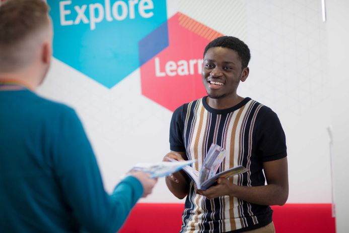 A student smiling at the Student Hub
