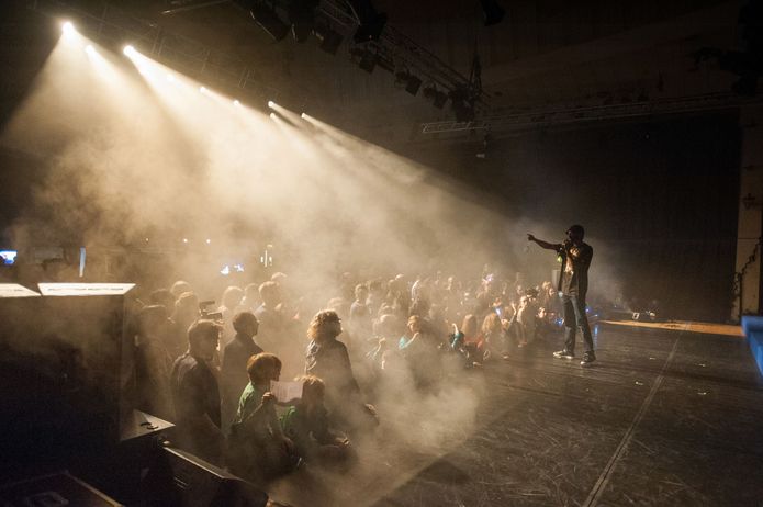 A performer on stage speaks to a crowd